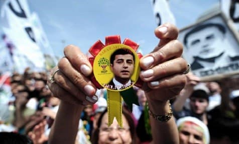 A woman holding a badge bearing the face of Selahattin Demirtaş, during an election rally in May 2015. Photo: Ozan Kose/AFP/Getty Images