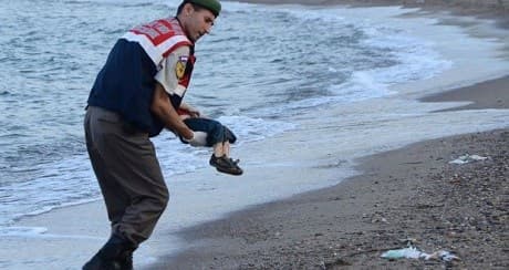 A Turkish paramilitary police officer carries the body of Alan Kurdi, found washed ashore near the Turkish resort of Bodrum September 2, 2015. PHOTO: AP