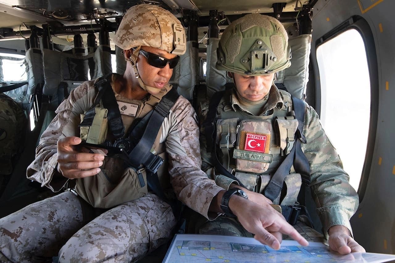 US Marine Corps Lt. Col. Roe Lemons and Turkish Army Maj. Mahmijt Ceylan discuss areas during a joint aerial patrol of the security mechanism zone over northeast Syria in a Louisiana National Guard UH-60 Black Hawk helicopter, September 12, 2019. Photo: US Army / Staff Sgt. Andrew Goedl via CENTCOM