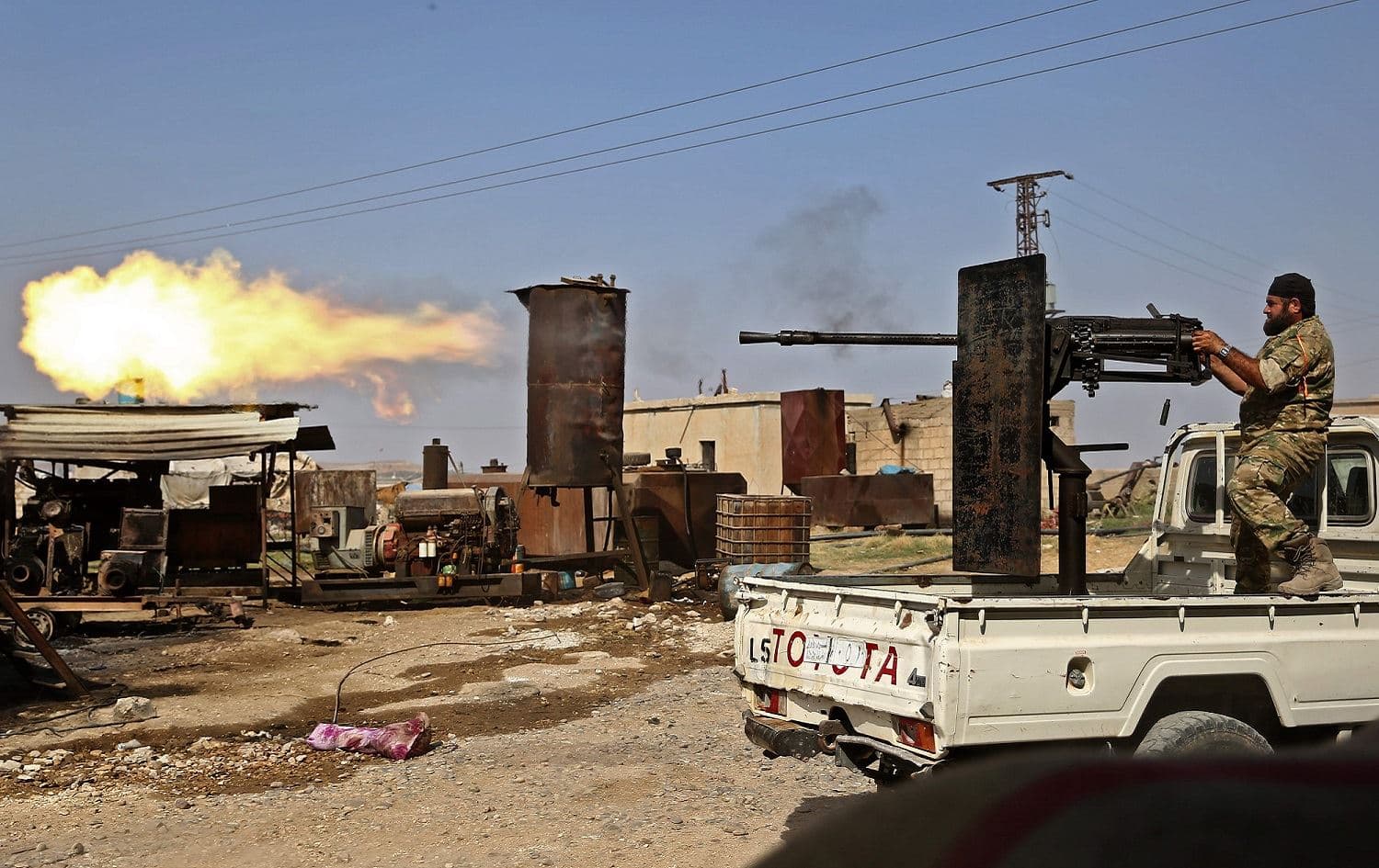A Turkish-backed Syrian fighter fires during clashes in the border town of Ras al-Ain, October 13, 2019. Photo: Nazeer al-Khatib / AFP