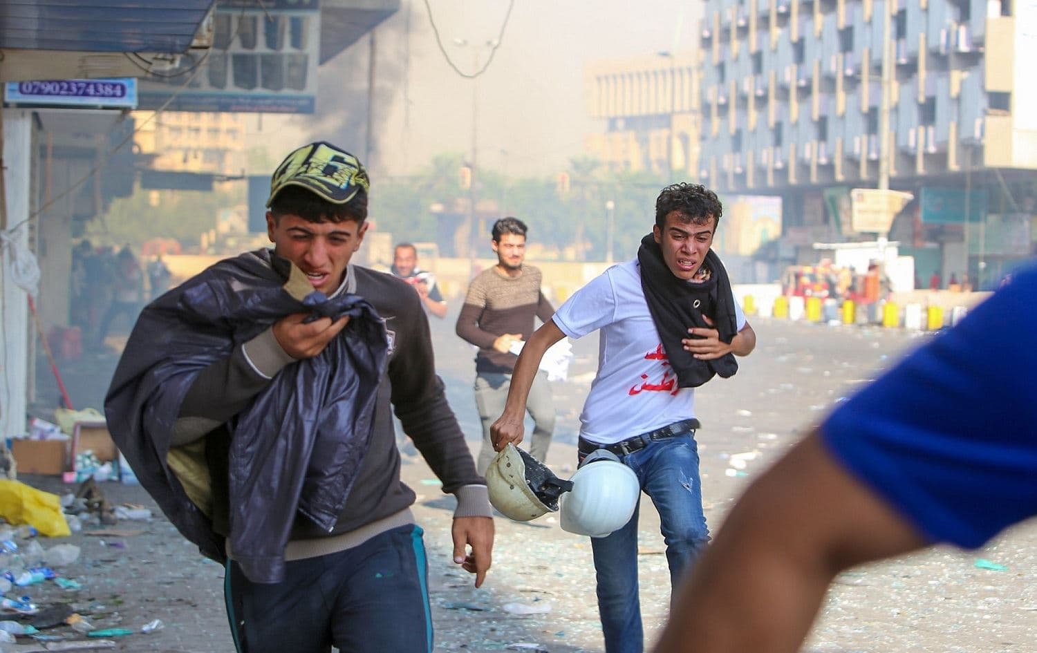 Iraqi protesters run for cover from teargas fired by security forces in al-Khalani square in central Baghdad on November 10, 2019. Photo: Sabah Arar/AFP