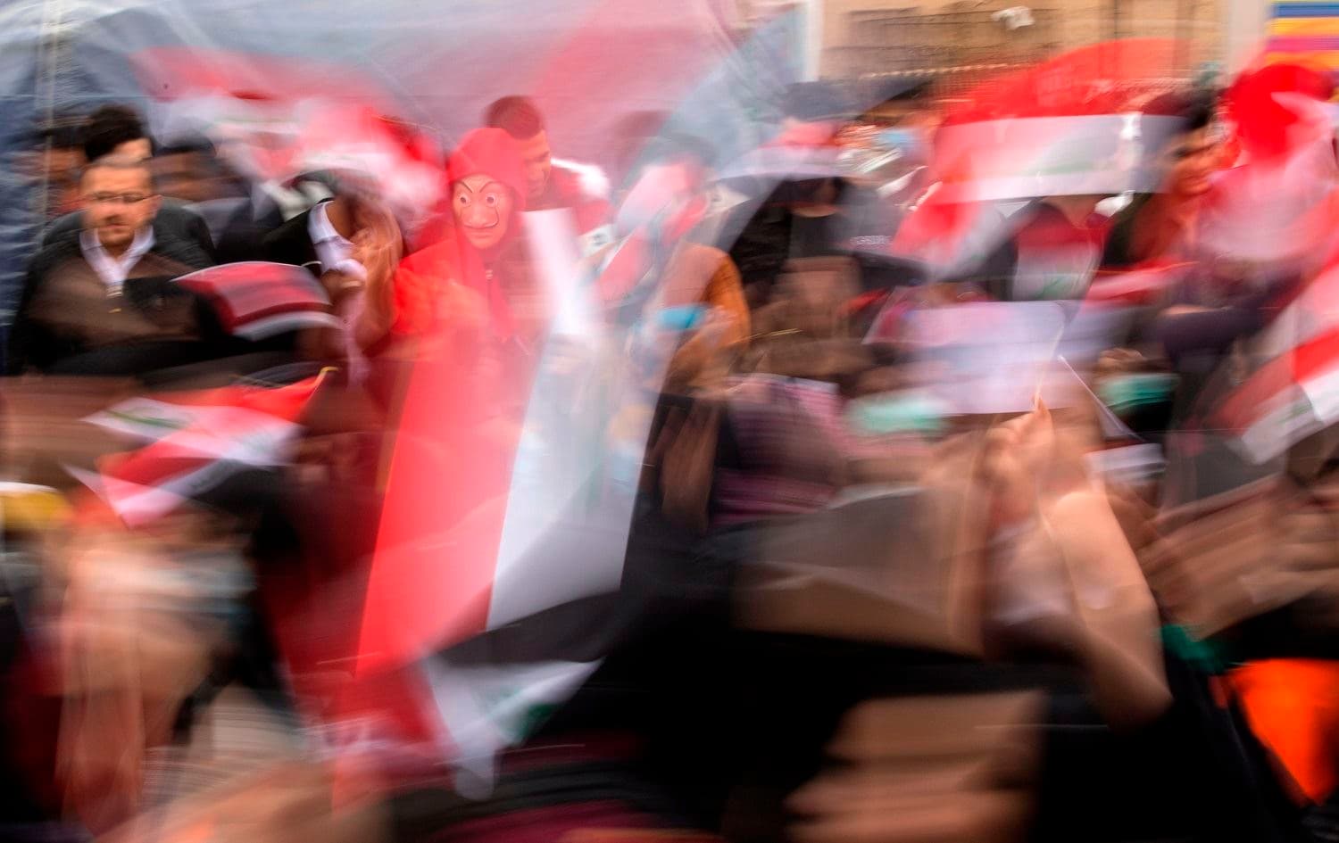 Iraqi demonstrators wave the national flag during an anti-government march in the center of the southern city of Basra on December 2, 2019. Photo: AFP / Hussein Faleh
