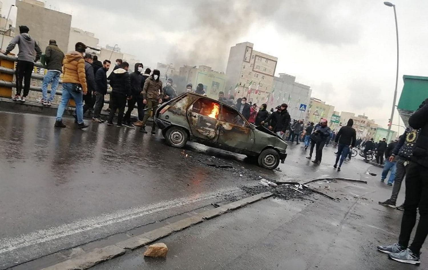 Iranian protesters gather around a burning car during a demonstration in Tehran on November 16, 2019. Photo: AFP