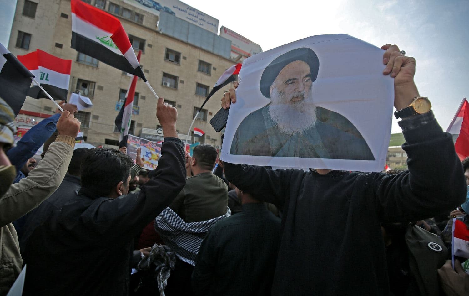 Iraqi supporters of the Hashd al-Shaabi paramilitias carry pictures of the country’s top Shiite cleric, Grand Ayatollah Ali Sistani, in Baghdad's Tahrir Square, December 5, 2019. Photo: Ahmad al-Rubaye / AFP