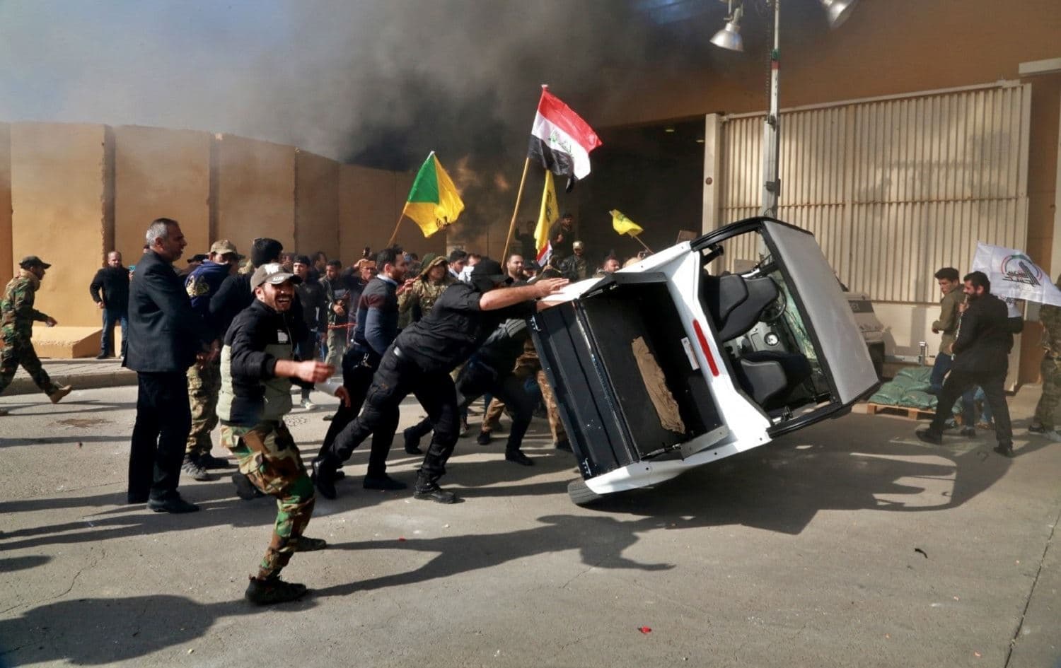 Protesters destroy a vehicle inside the US Embassy compound in Baghdad on Tuesday. Photo: AP / Khalid Mohammed