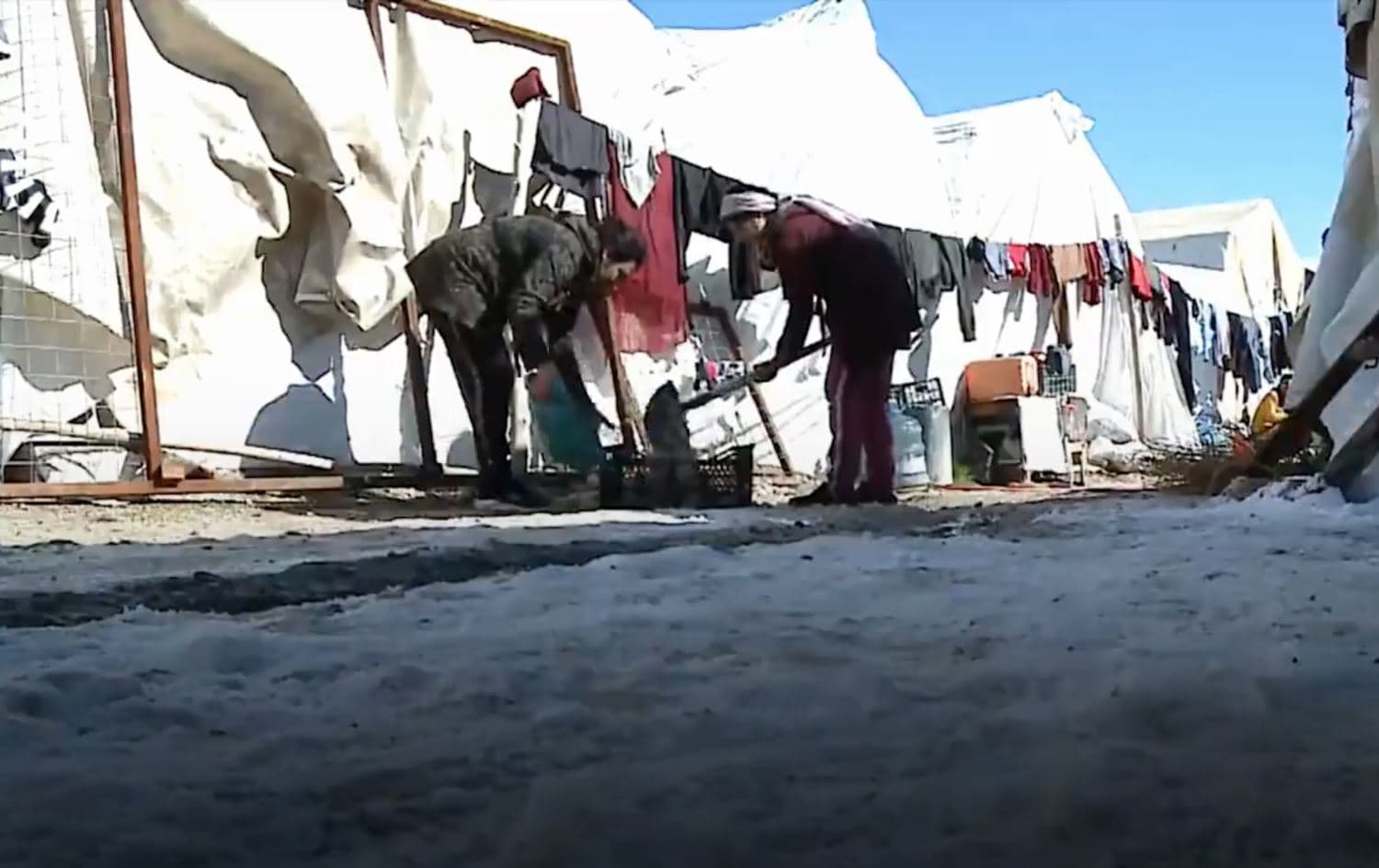Yezidi women shovel snow outside their tents in Sharia camp, Duhok province, Kurdistan Region of Iraq, February 2020. Photo: Rudaw TV