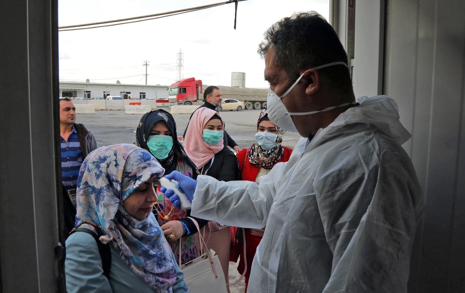 A medic checks the body temperature of travelers arriving to an Erbil checkpoint on March 2, 2020. Photo: Safin Hamed/AFP