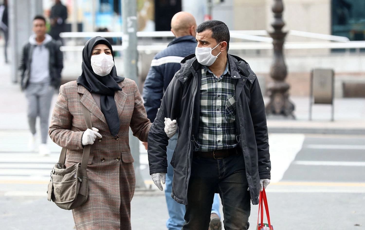 Pedestrians wearing facemasks walk on a street in Ankara, March 30, 2020. Photo: Adem Altan / AFP