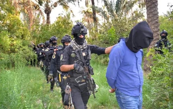 In this July 8, 2020 handout photo, Iraqi forces arrest a suspected ISIS member in operations against the group north of Baghdad. Photo: Iraq Counter-Terror Service/handout