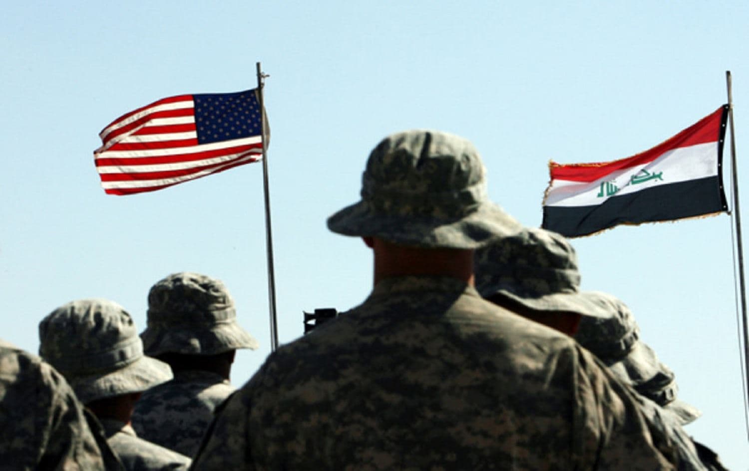 US troops stand to attention in front of American and Iraqi flags suring a handover ceremony near the town of Hawija on May 15, 2011. Photo:Ali al-Saadi/AFP