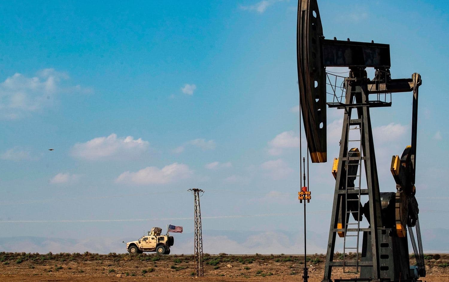 An American military vehicle passes an oil pump in Qamishli, Syria. File photo: Delil Souleiman/AFP