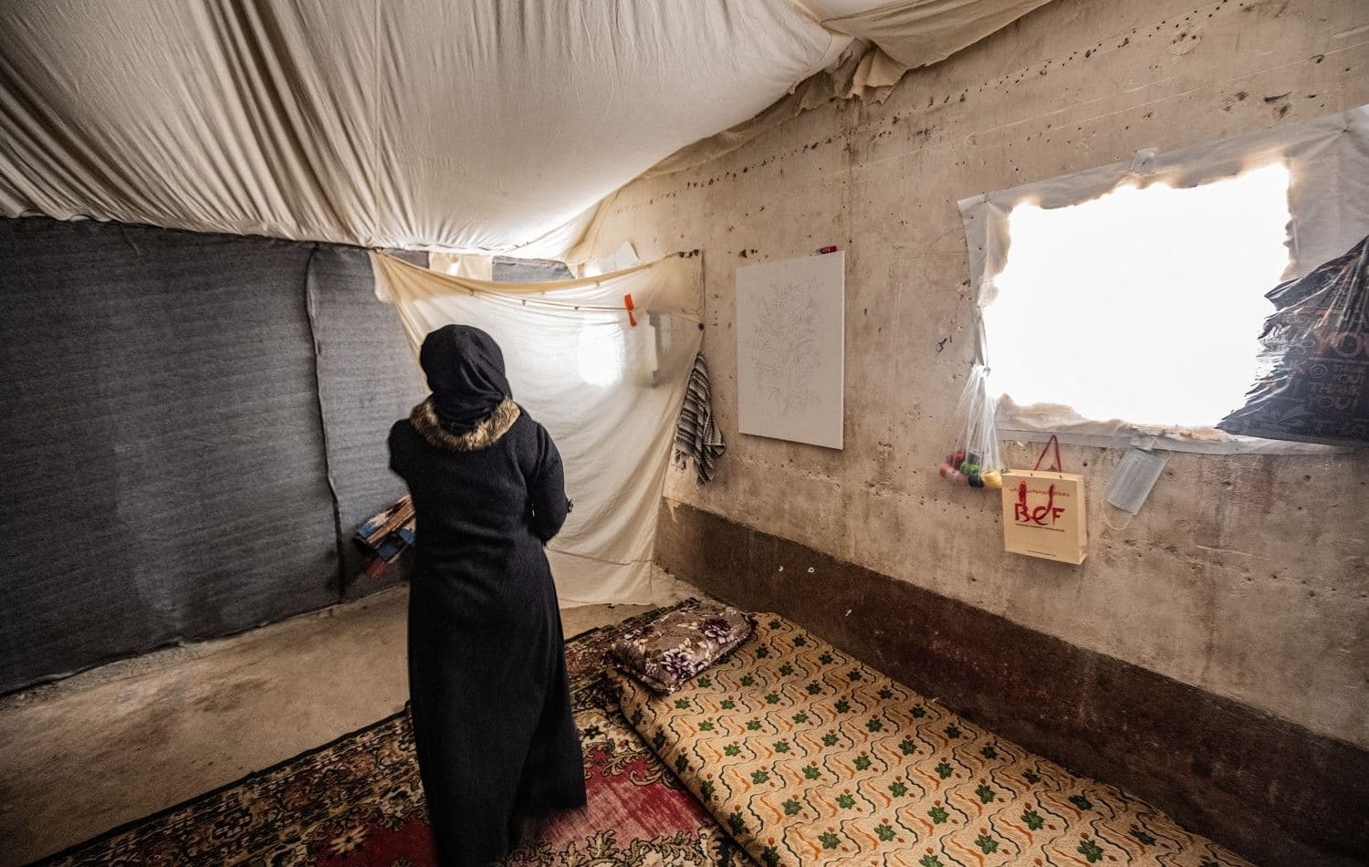 A woman stands in her temporary housing unit home at Hassan Sham U3 camp, Nineveh province on November 26, 2020. Photo: Bilind T. Abdullah/ Rudaw
