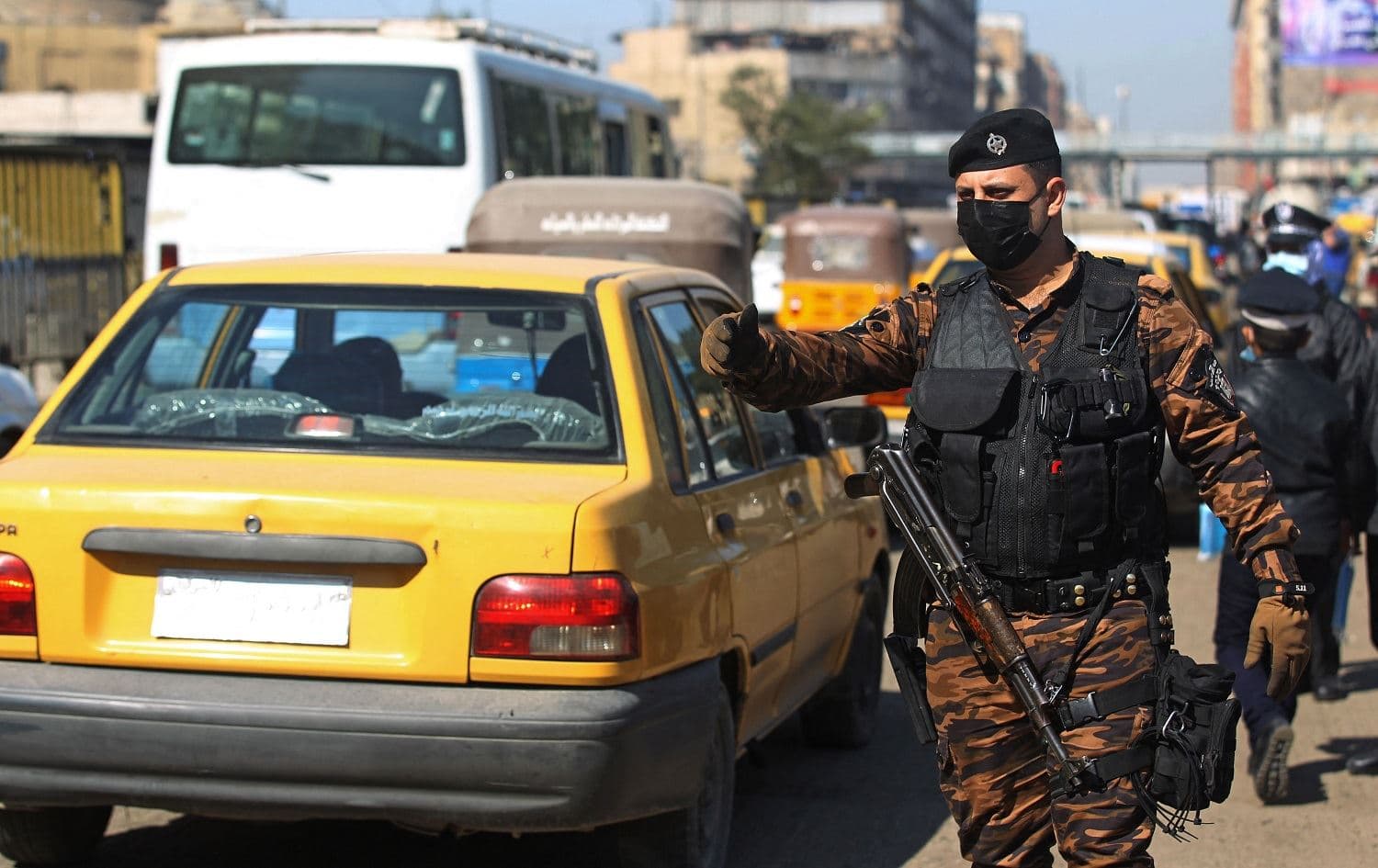 An Iraqi policeman directs traffic during COVID-19 testing at Baghdad's Shorja market on February 22, 2021. Photo: Ahmad al-Rubaye/AFP