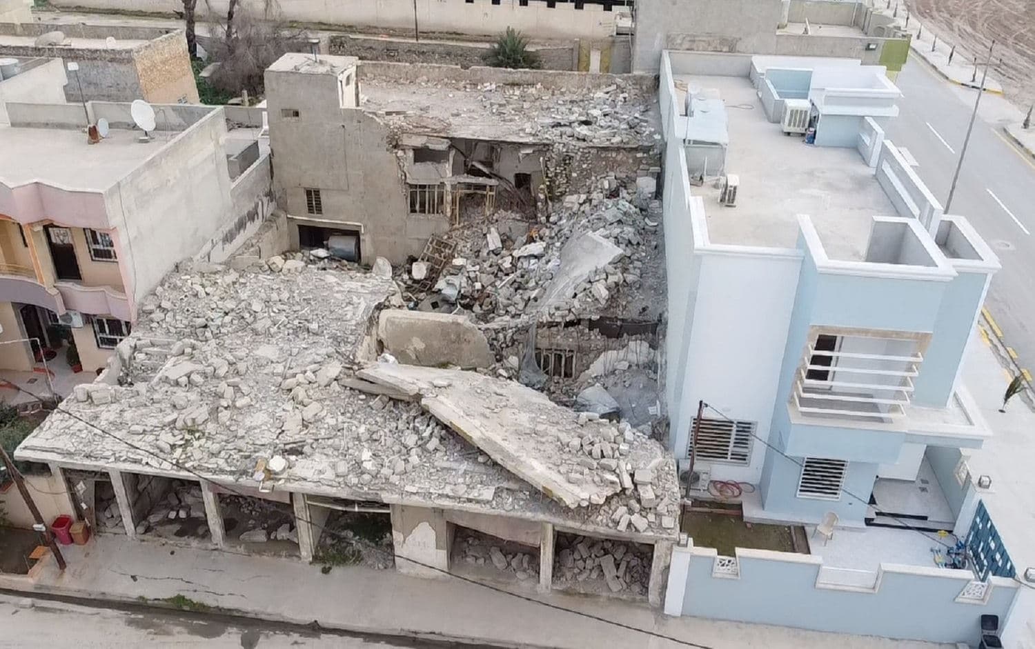 Ikram's newly-rebuilt home standing next to a bombed-out house in Qaraqosh on March 2, 2021. Photo: Bilind T. Abdullah / Rudaw