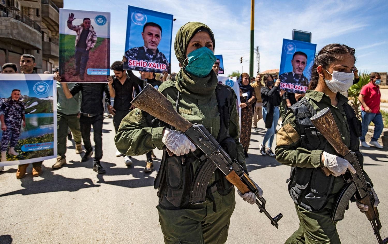 Members of the Syrian Kurdish internal security services (Asayish) march in a procession on April 22, 2021 ahead of the body of their fallen comrade Khalid Hajji, who was killed following clashes with pro-regime forces in Qamishli. Photo: Delil Souleiman/AFP