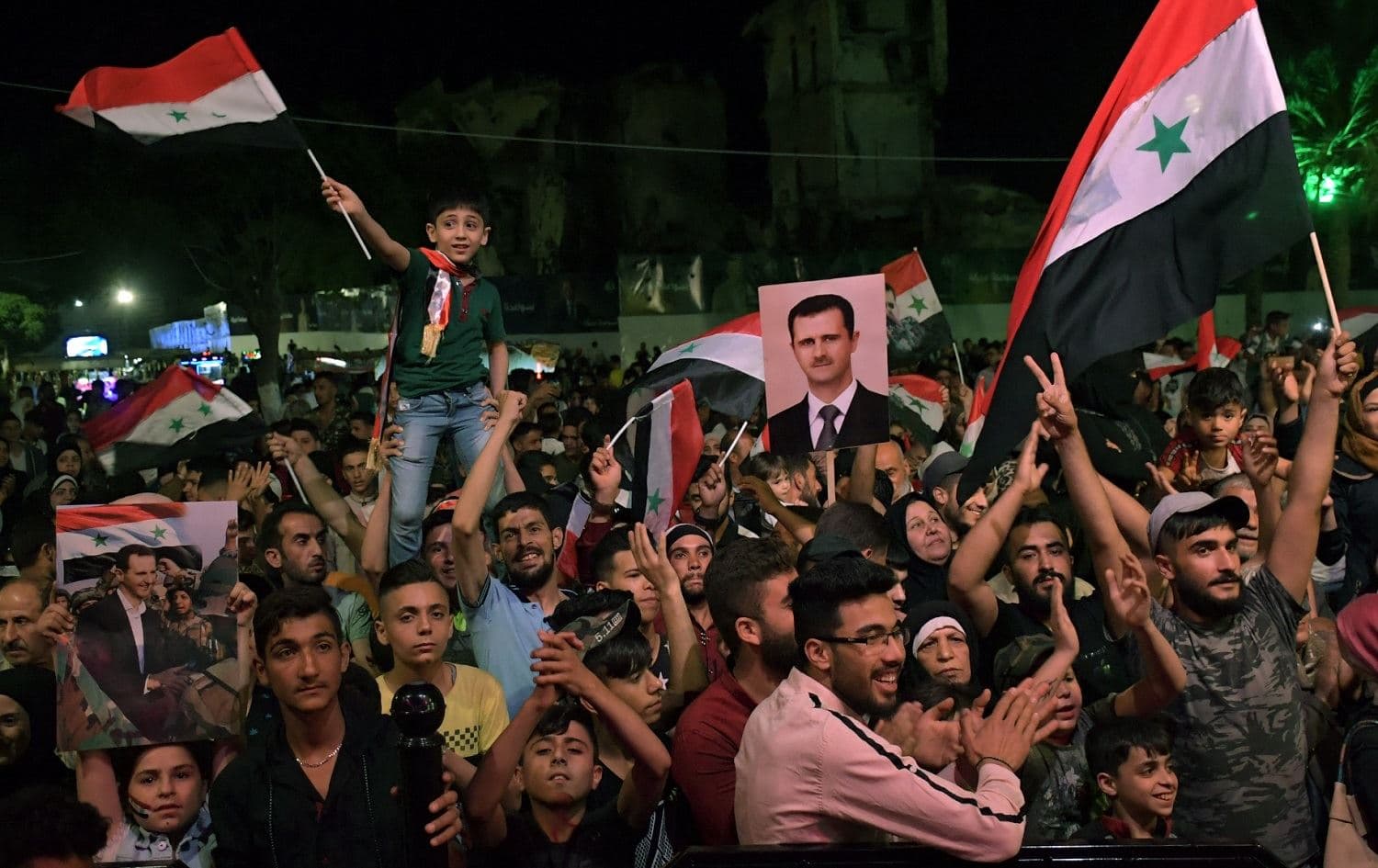 Syrians celebrate in the streets of Aleppo as President Bashar al-Assad was re-elected for a fourth term as president of war-ravaged Syria, late on May 27, 2021. Photo: AFP