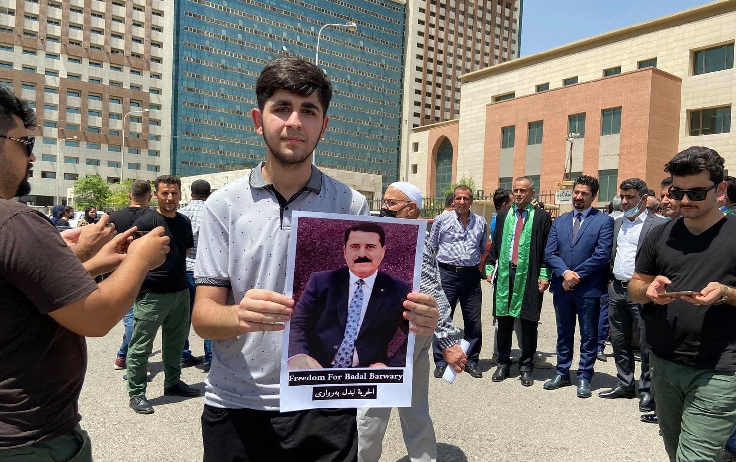 A nephew of Badal Barwari holds up a photo of his jailed uncle outside of the Erbil criminal courthouse on Thursday, July 29, 2021. Photo: Dilan Sirwan/ Rudaw