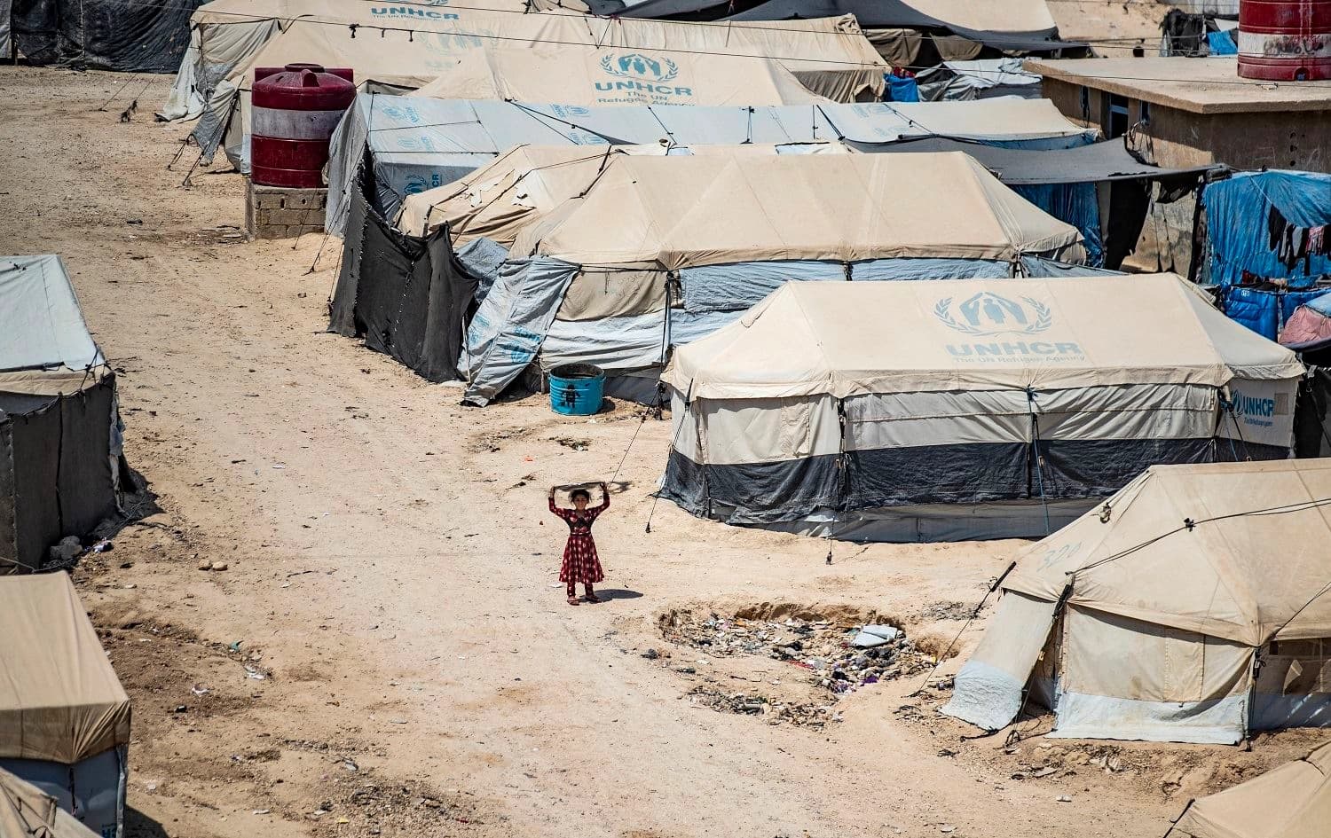 A girl looks on among shelters at al-Hol camp. Photo: Delil Souleiman/AFP