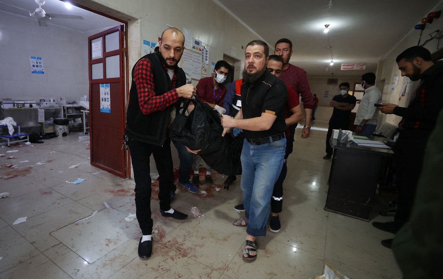 Syrians carry a body in a hospital in Ariha, Idlib on October 20, 2021. Photo: Omar Haj Kadour/AFP