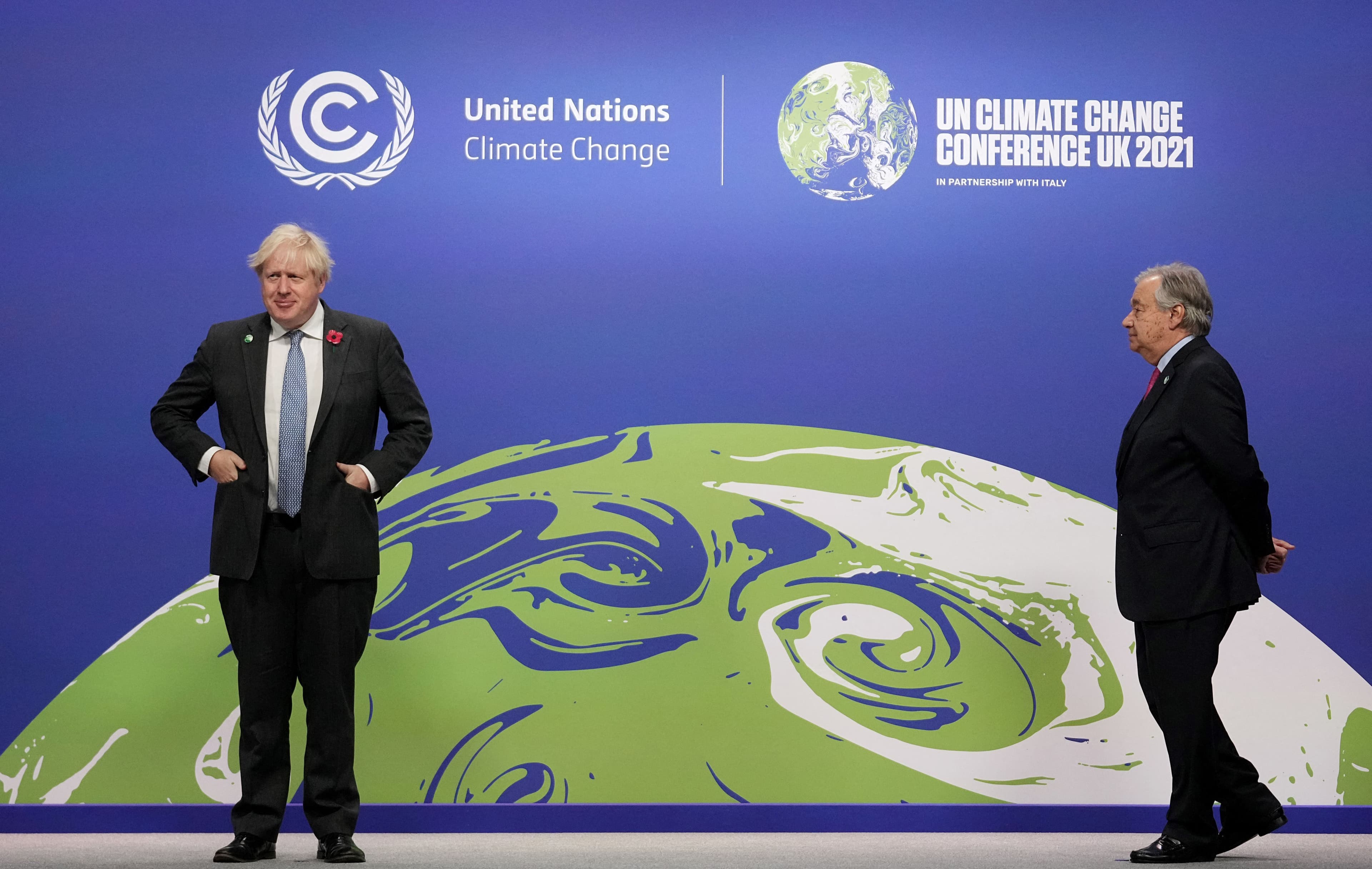 Britain's Prime Minister Boris Johnson (L) and United Nations (UN) Secretary General Antonio Guterres wait to greet leaders as they arrive to attend the COP26 UN Climate Change Conference on November 1, 2021. Photo: Christopher Furlong/ POOL/ AFP.
