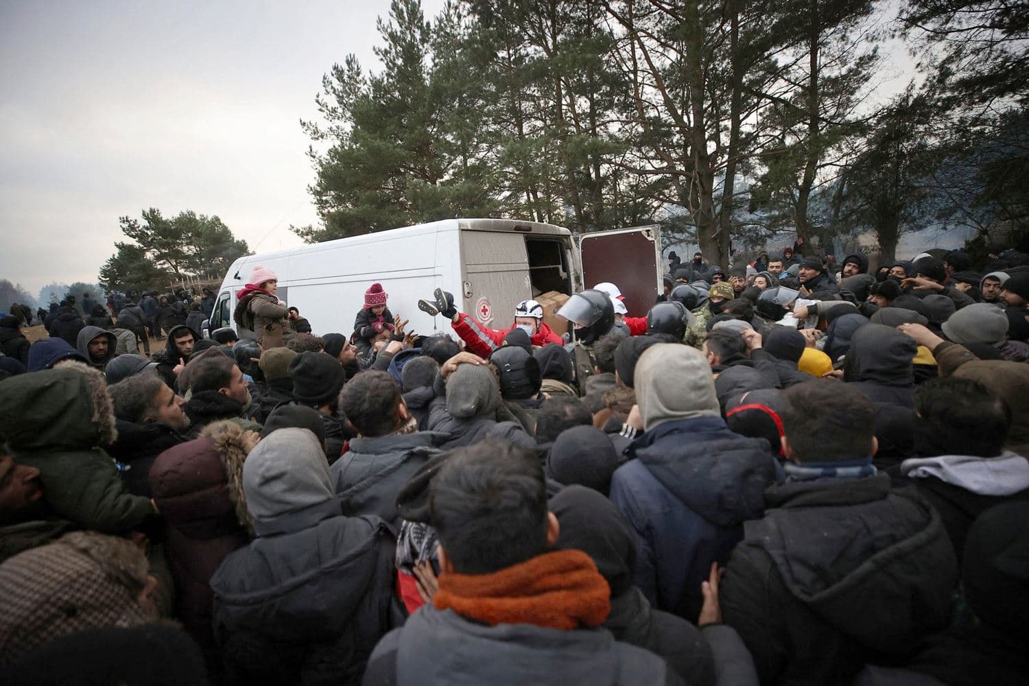 A group of migrants gather to receive humanitarian aid in a camp near the Belarusian-Polish border in the Grodno region on November 13, 2021. Photo: Leonid SHCHEGLOV/AFP