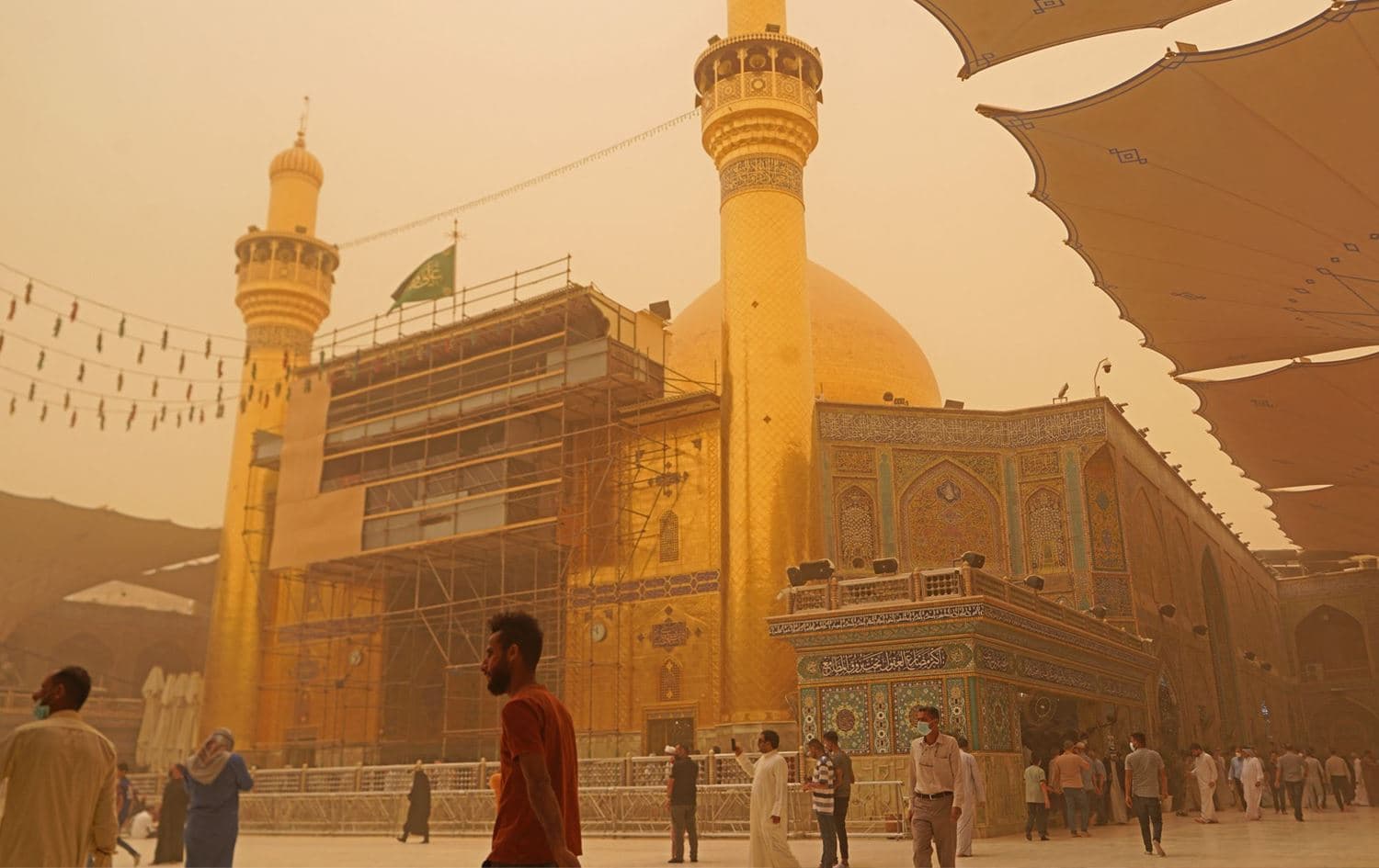 Iraqis visit the Imam Ali shrine during a sandstorm in Iraq's holy city of Najaf on May 5, 2022. Photo: AFP