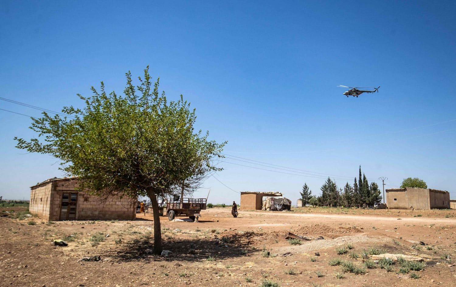 A military helicopter hovers over a town in Syria's northeastern Hasaka province on July 14, 2021. Photo: Delil Souleiman/AFP