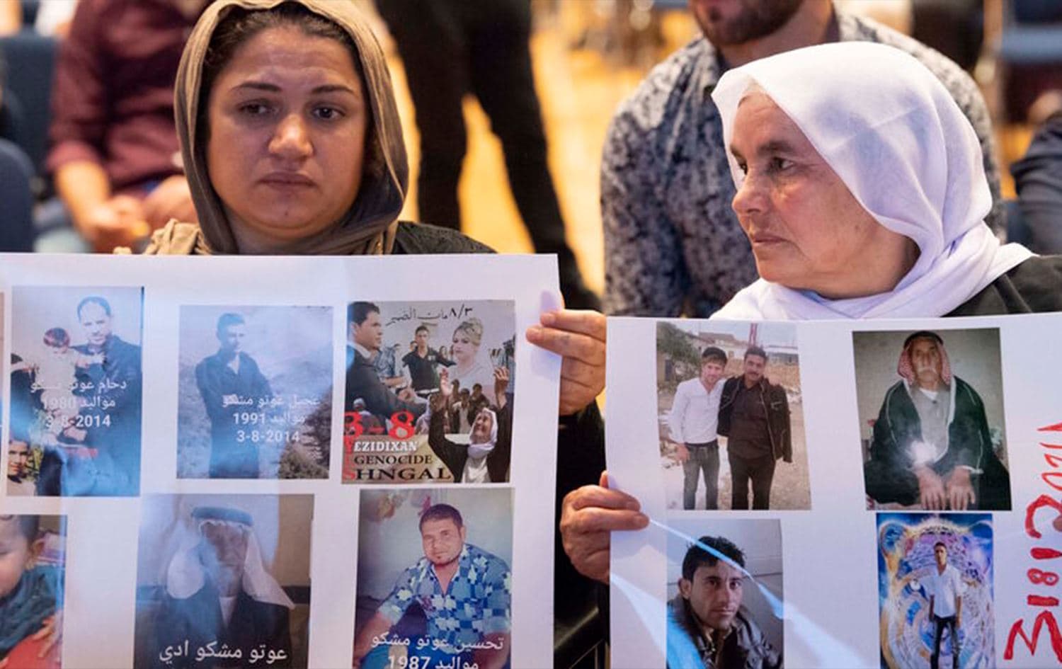 Yazidi women hold up pictures of missed relatives during a commemoration ceremony in Germany. File photo: AFP