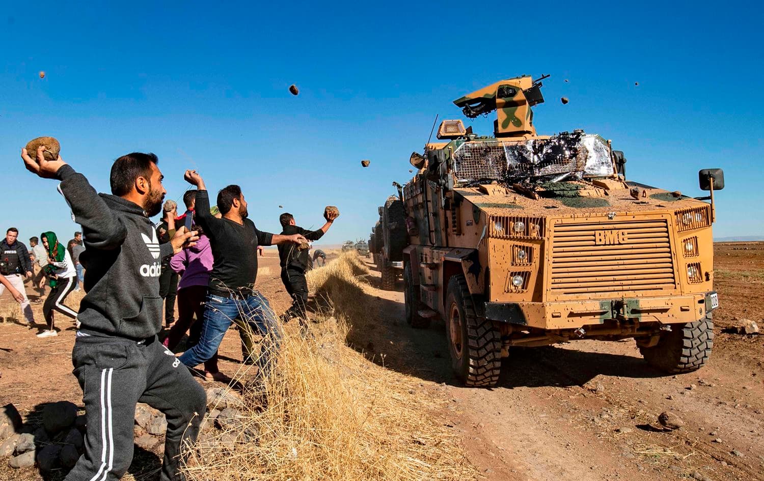 Kurdish demonstrators hurl rocks at a Turkish military vehicle on November 8, 2019, during a joint Turkish-Russian patrol in Hasaka. Photo: Delil/Souleiman/AFP