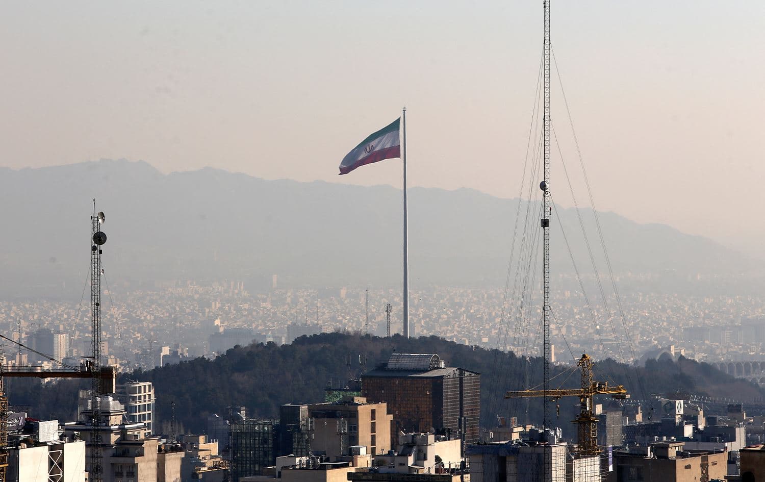 A general view shows the Iranian capital Tehran on January 7, 2023, with the Iranian flag fluttering in the wind. Photo: Atta Kenare/AFP