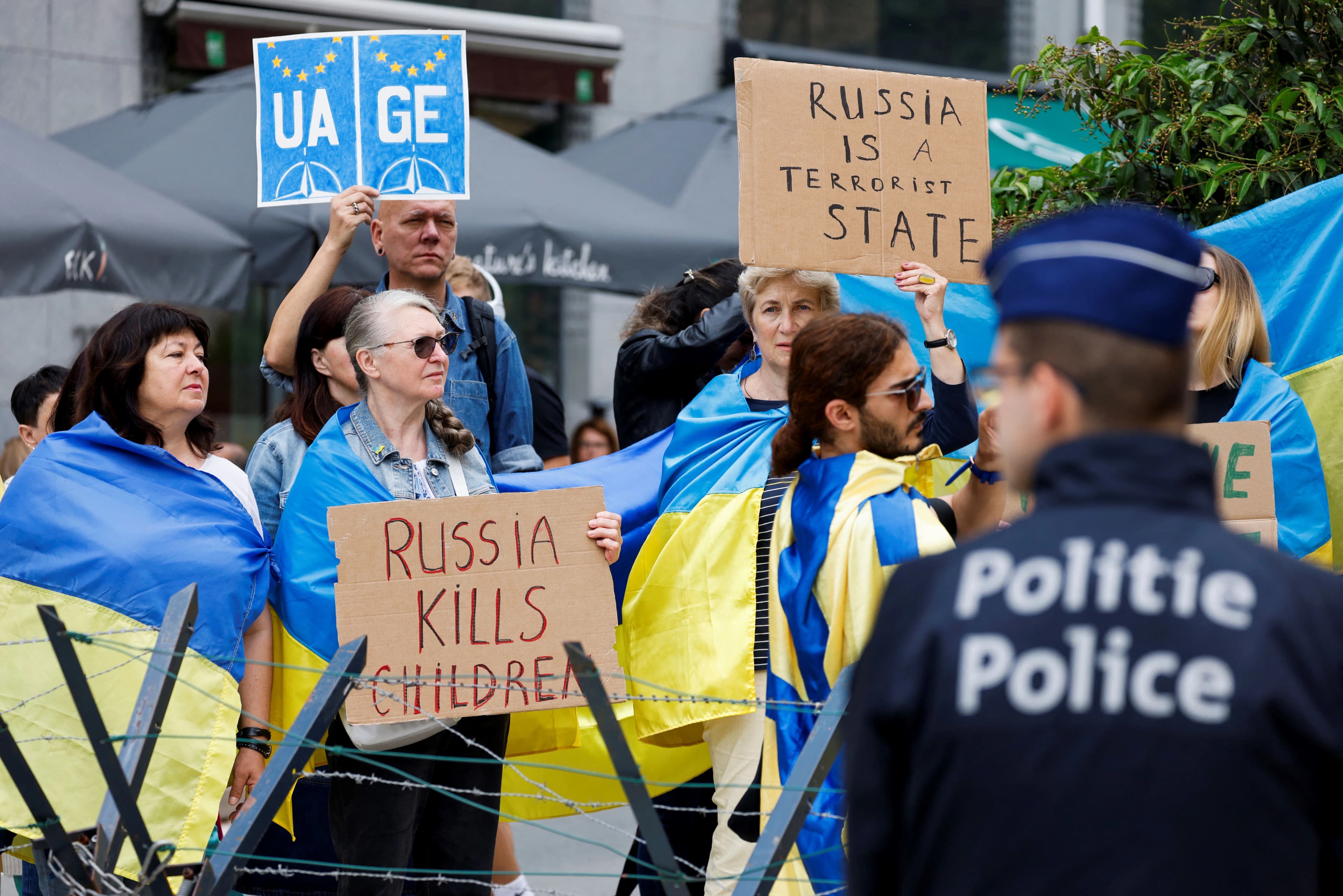 Protestors hold Ukrainian flags and signs during a pro-Ukraine protest, near EU council, in Brussels, on June 29, 2023. Photo: AFP