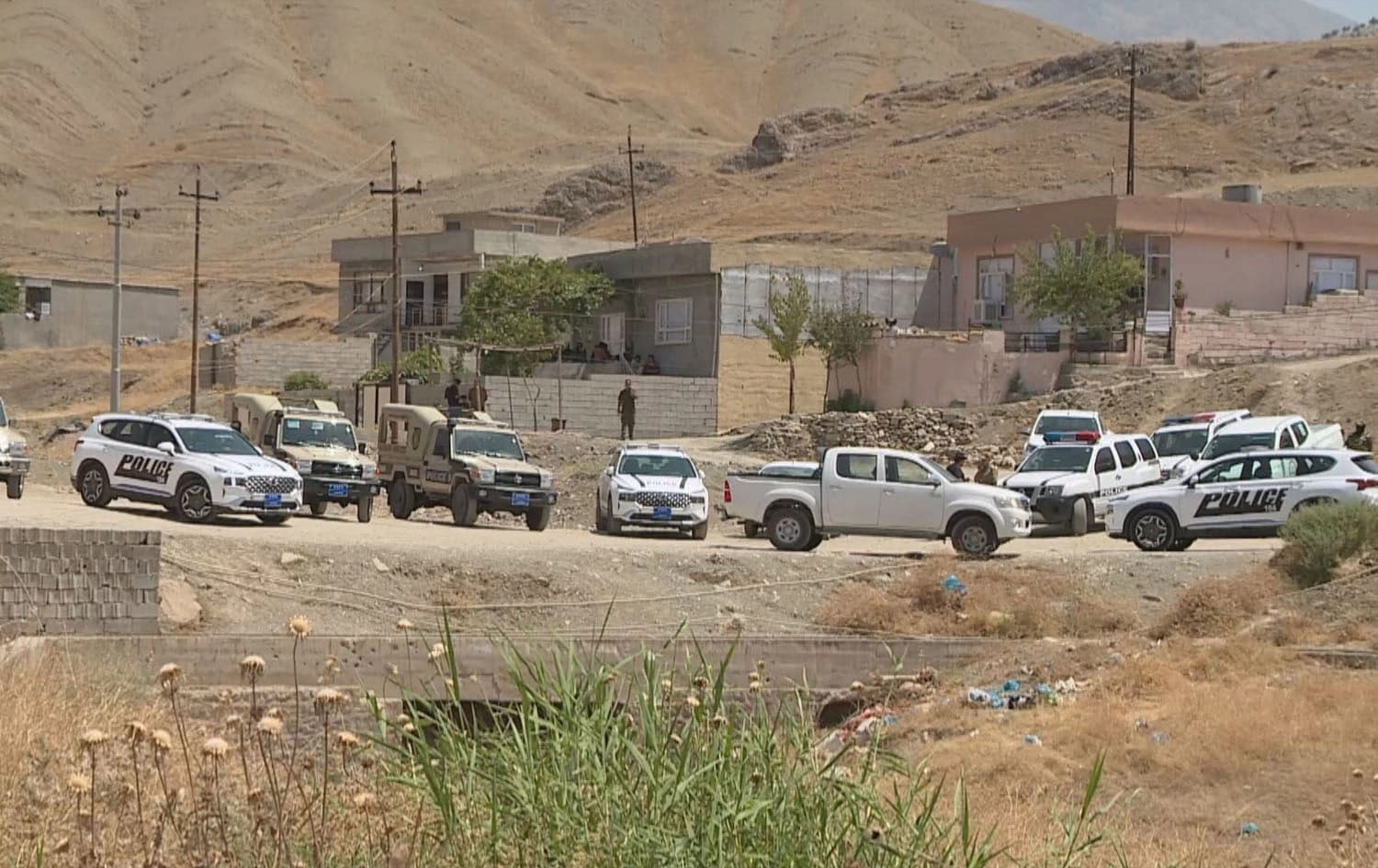 Police vehicles in front of the houses where the incident happened on July 29, 2023. Photo: Rudaw
