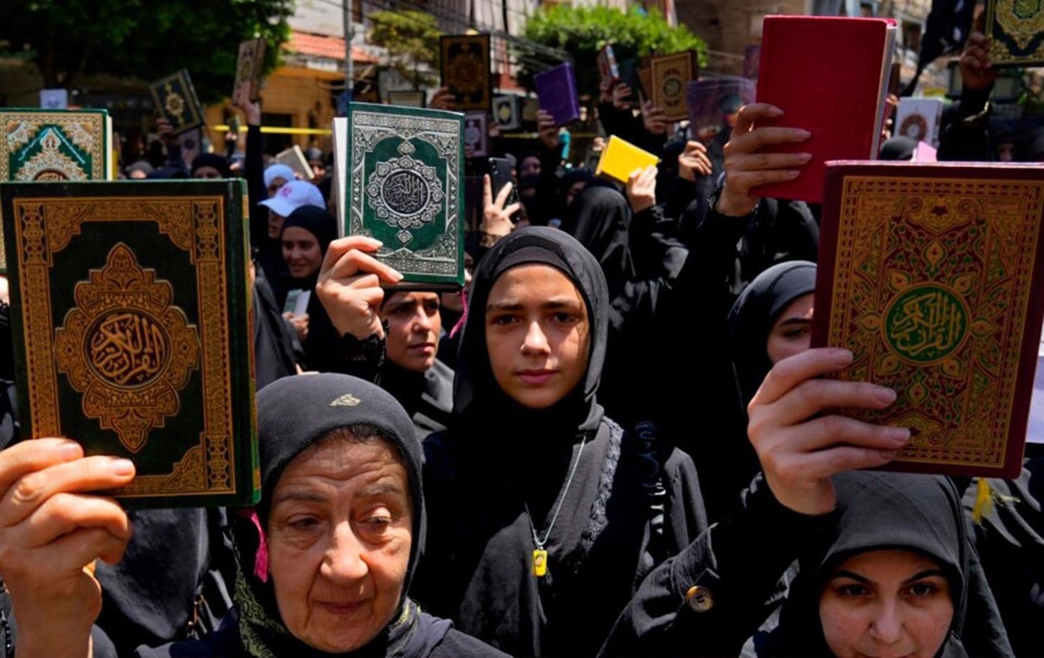 Beyrut’ta Hizbullah destikçileri Kuran yakma eylemlerini protesto etmek amacıyla ellerinde Kur’an ile yürüyüş düzenledi / Foto: AP