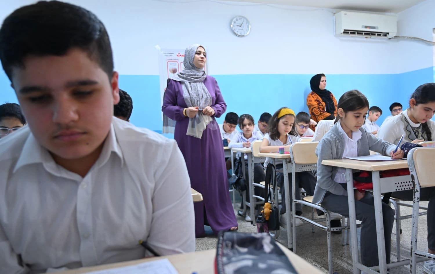 مامۆستایەک وانە بە قوتابییان دەڵێتەوە. وێنە: بڵند تاهیر - رووداو