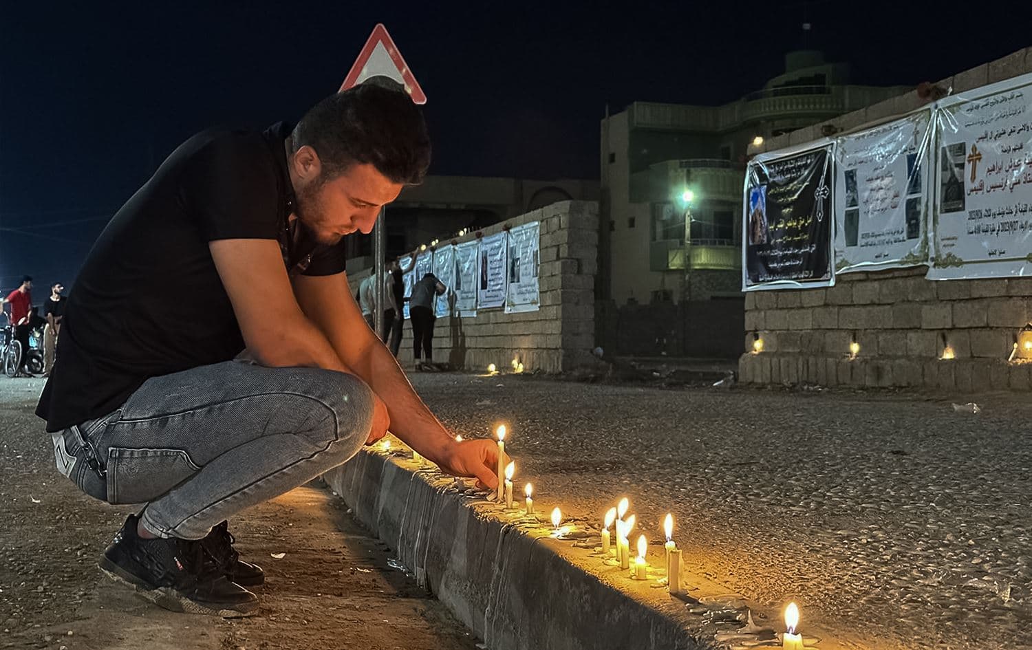 Mourner lights candle to honor the victims of the tragic blaze on September 27, 2023 in Nineveh's Hamdaniya district. Photo: Rudaw