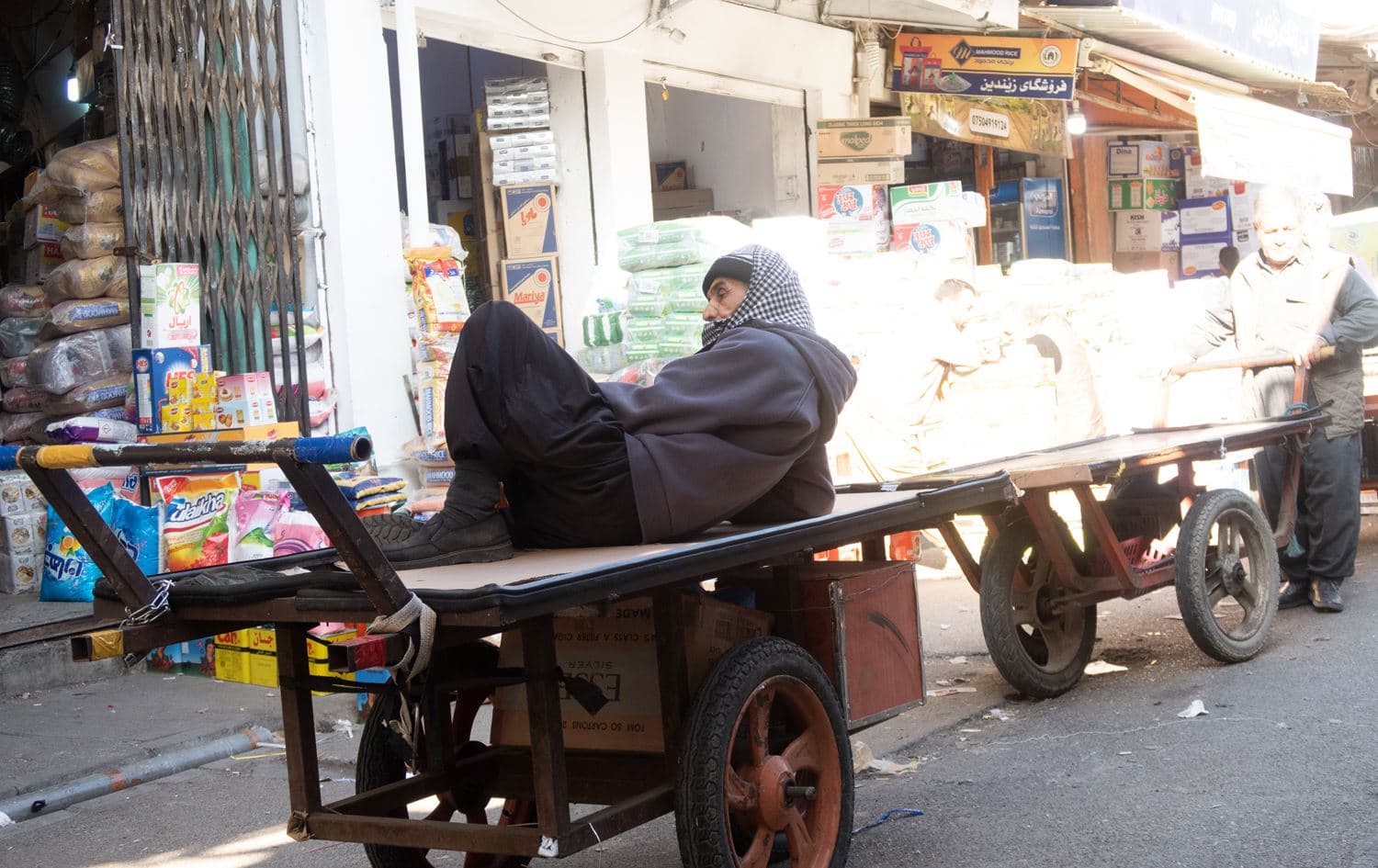 A street vendor lies down on his cart in an Erbil bazaar due to the market inactivity. Photo: Bilind T. Abdullah/Rudaw