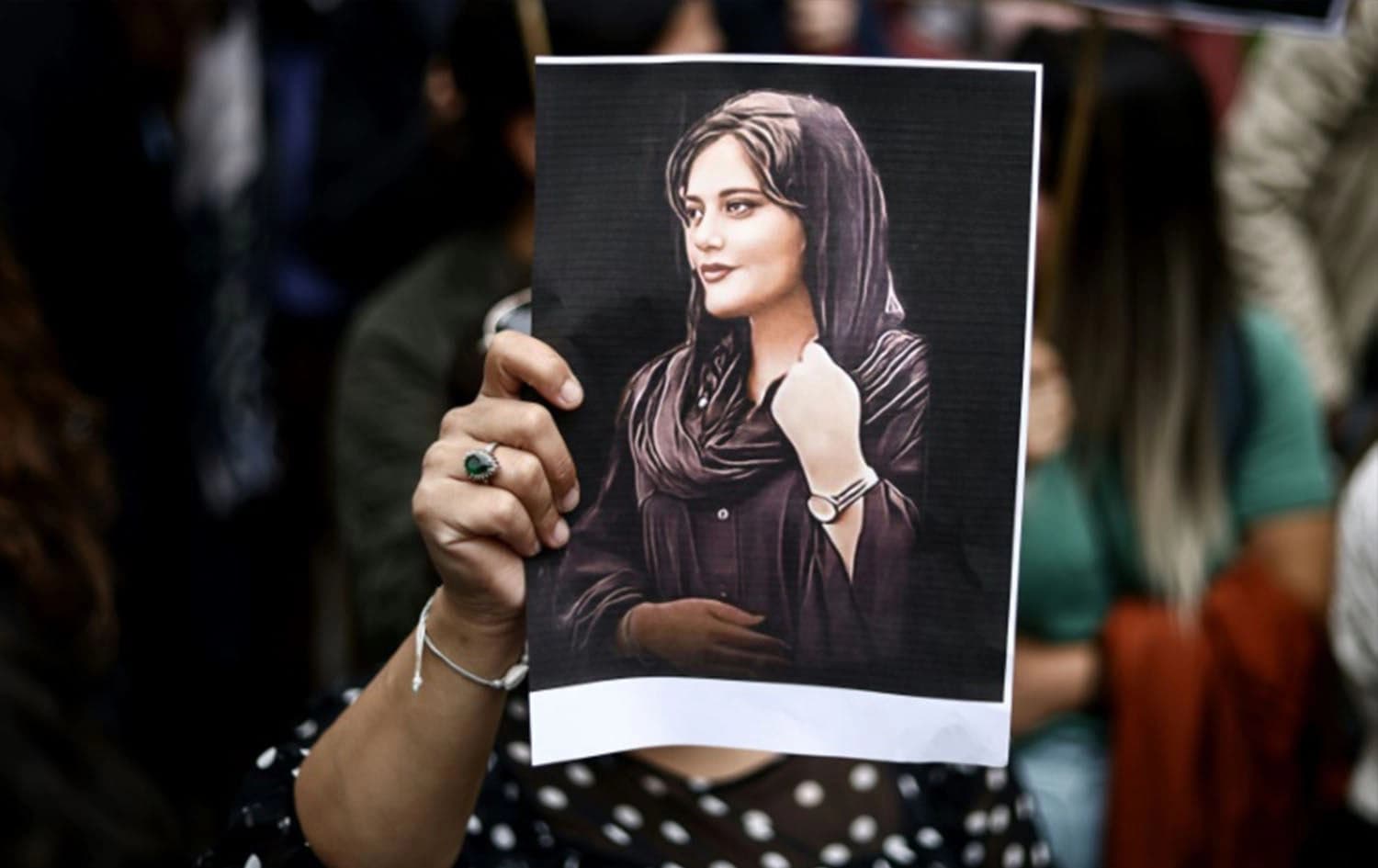 A protester holds a portrait of Mahsa Amini. Photo: AFP