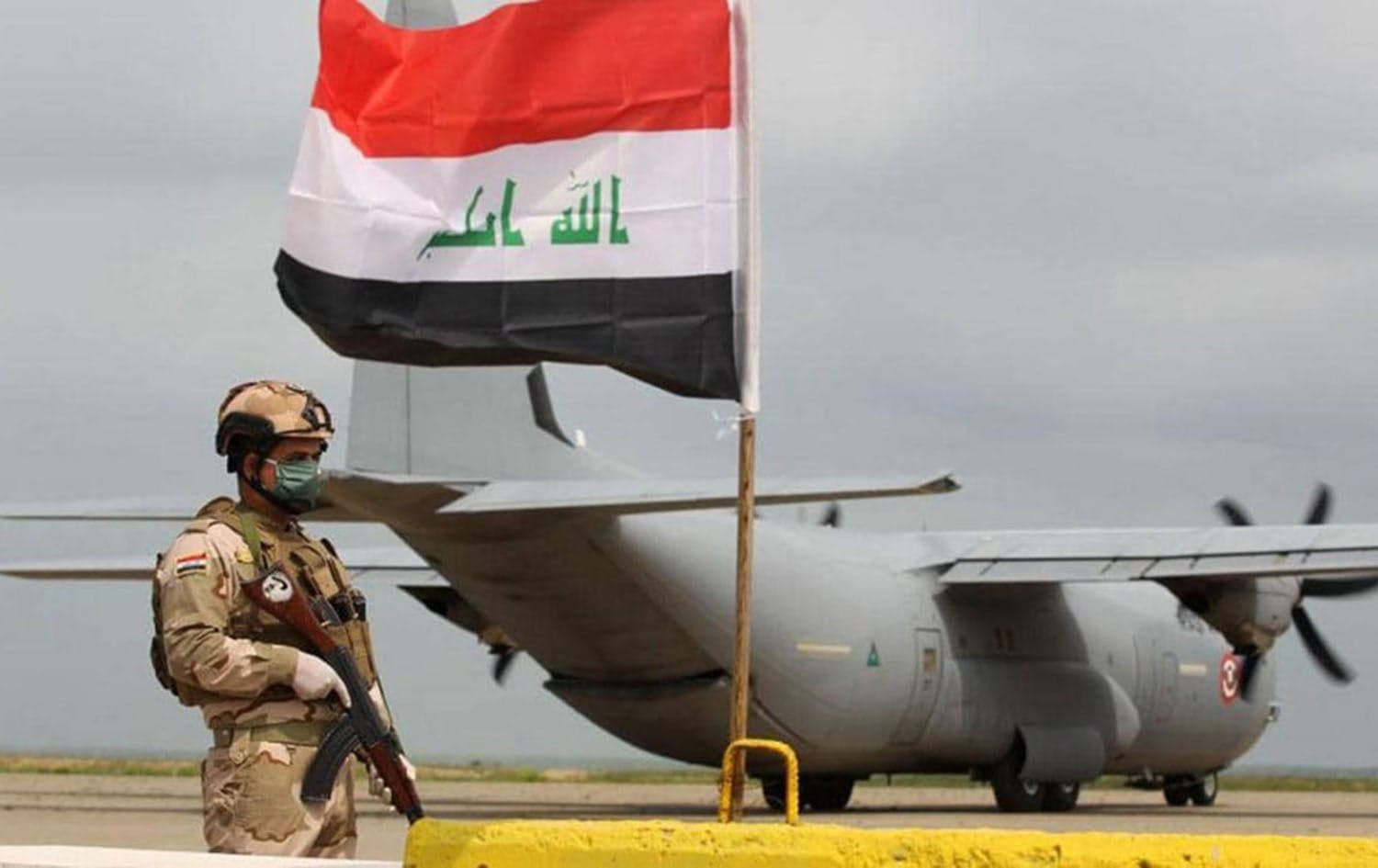 An Iraqi soldier stands guard in front of a US military air carrier at the Qayyarah airbase, near Mosul in northern Iraq, on March 26, 2020. Photo: AFP
