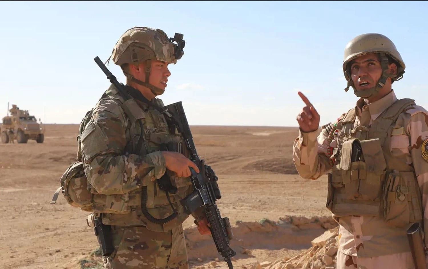 A US soldier (left) and an Iraqi soldier (right) speak with one another at al-Assad air base in western Iraq on December 21, 2021. Photo: US army