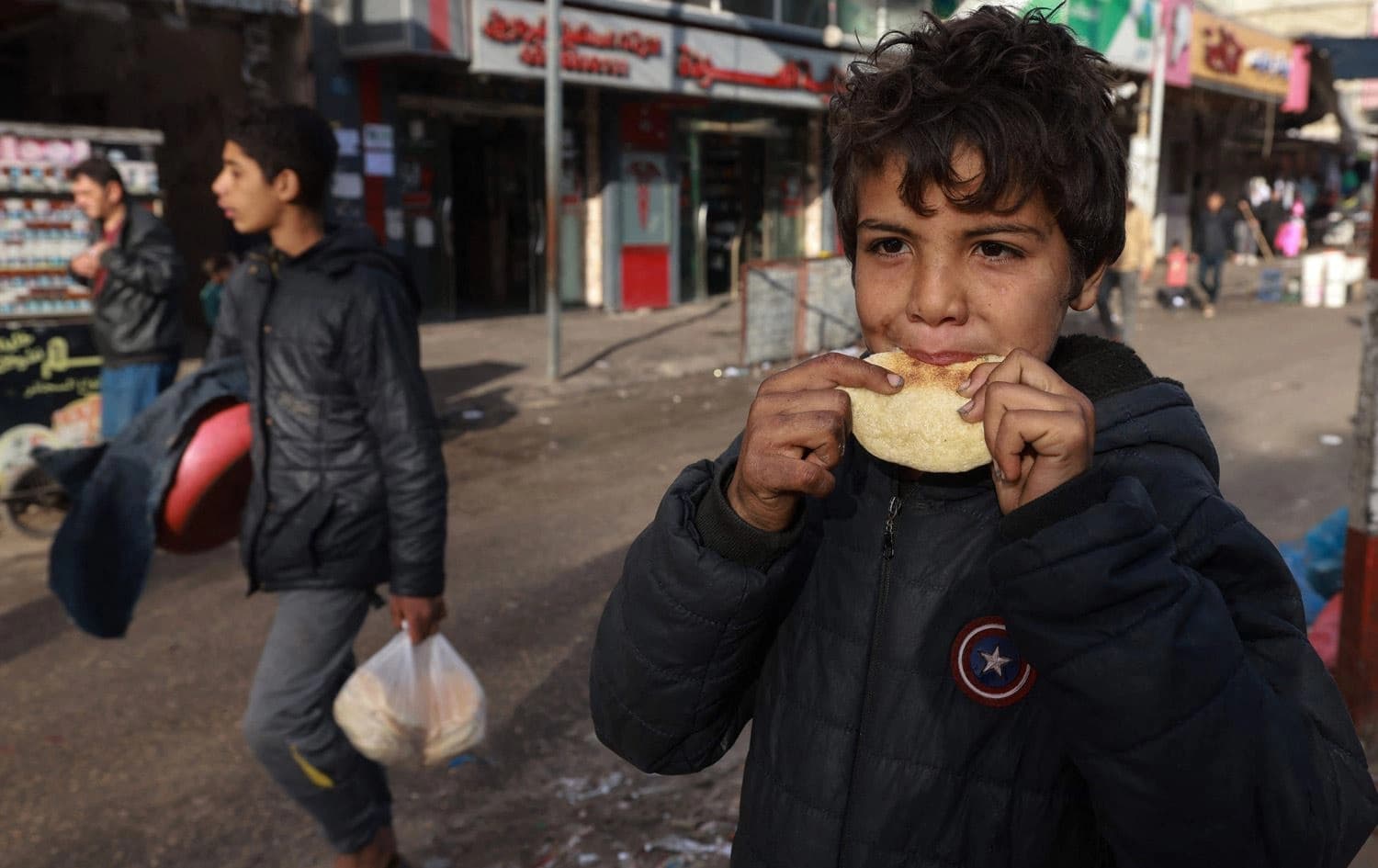 منداڵێک لە غەززە پارچەیەک نان دەخوات. وێنە: AFP