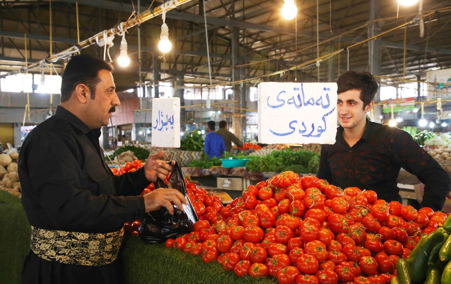 کڕیارێک لە بازاڕێکی سەوزە و میوەی هەرێمی کوردستان، تەماتە دەکڕێت. وێنە: رووداو/ ئەرشیڤ