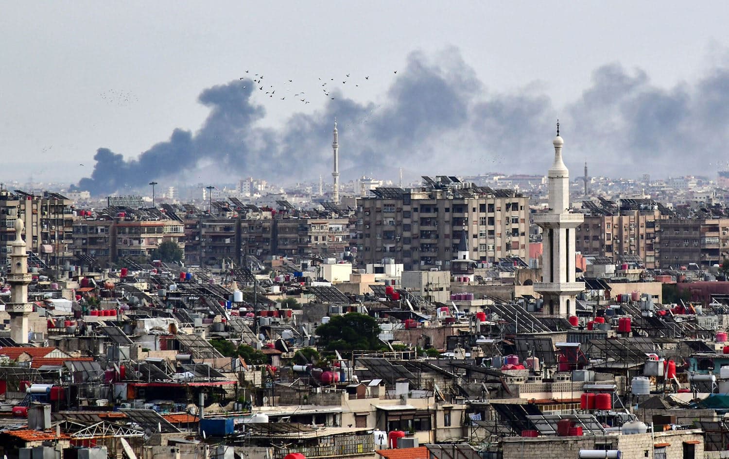 Smoke billows above buildings after an alleged Israeli strike on the outskirts of Damascus on November 22, 2023. Photo: AFP