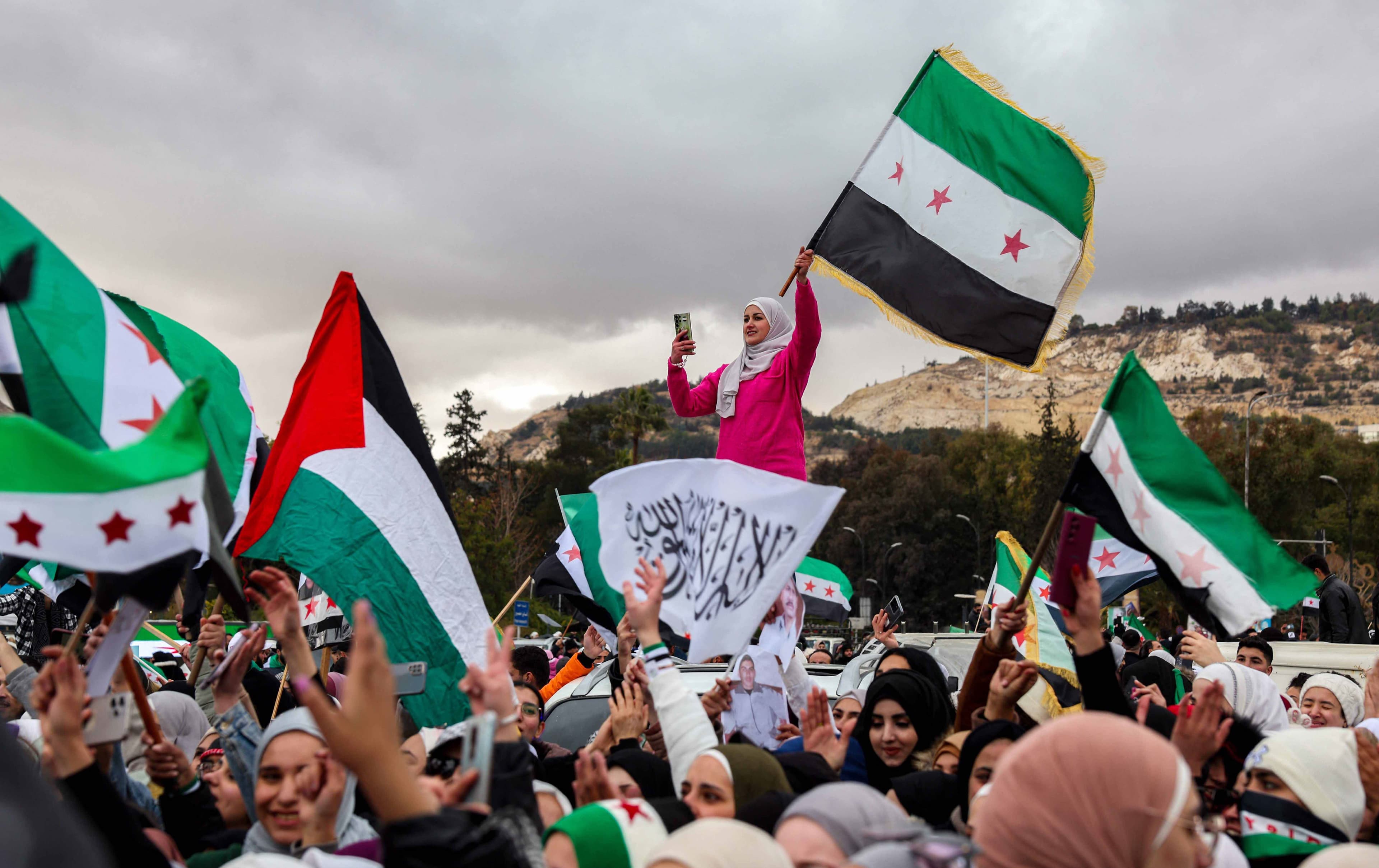 ئاهەنگگێڕانی سووریاییەکان بەبۆنەی کەوتنی ئەسەد. وێنە: OMAR HAJ KADOUR / AFP