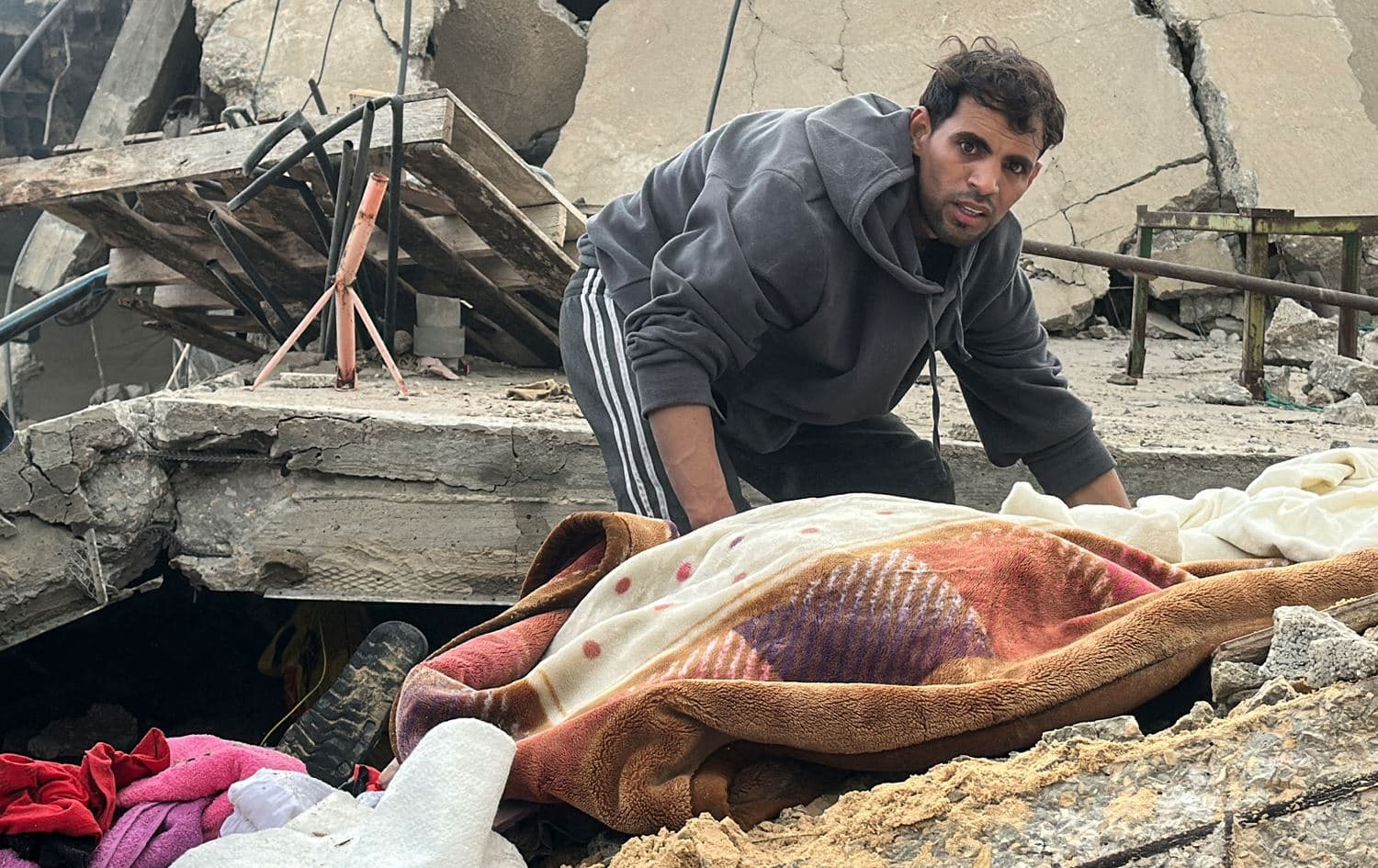 پیاوێک لە شاری خان یونس تەرمێکی لەژێر داروپەردوودا دەرهێناوە. وێنە: AFP