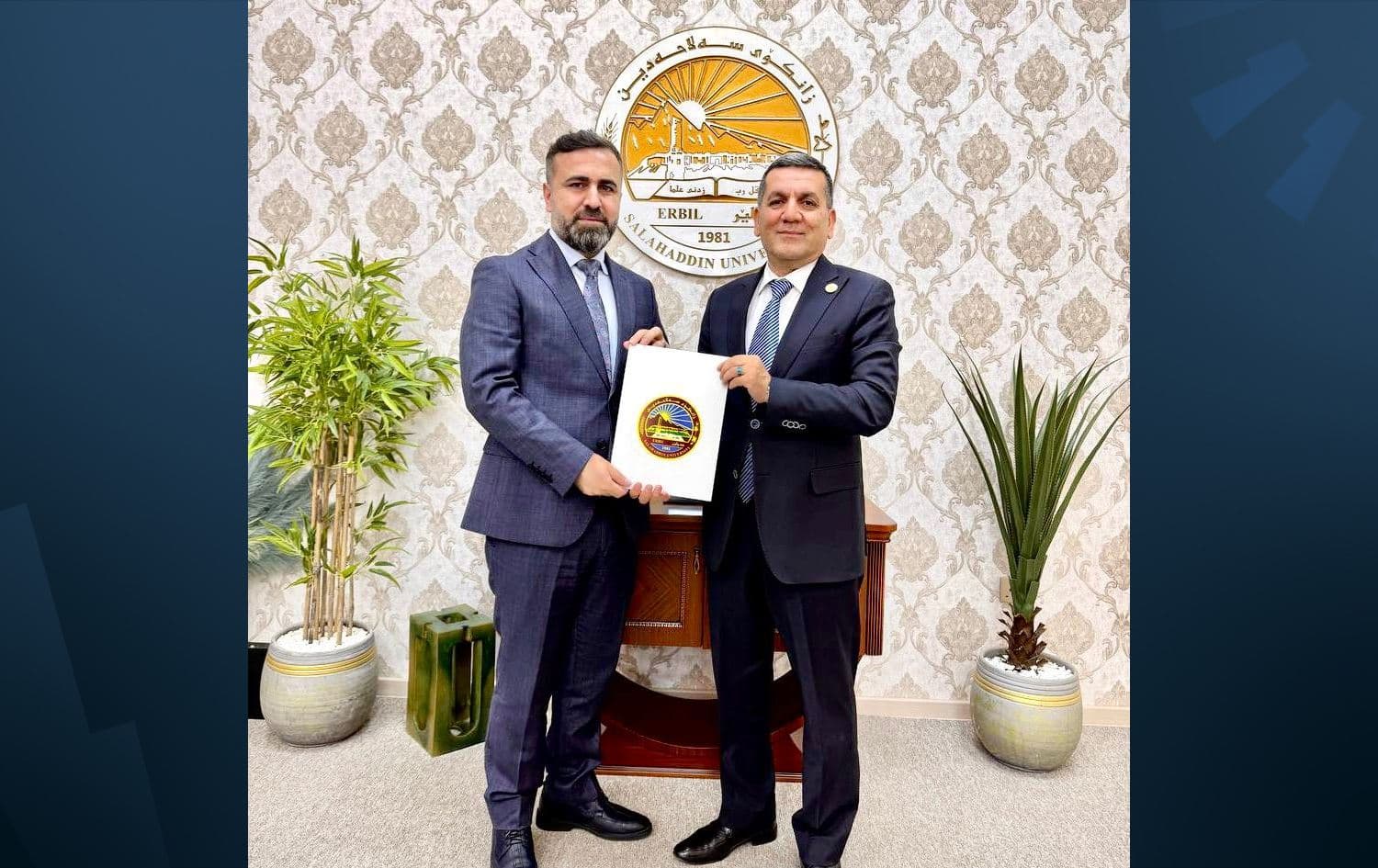 وێنەیەکی پرۆفیسیۆری یاریدەدەر کارزان شێخ موحسین لەگەڵ سەرۆکی زانکۆی سەلاحەدین