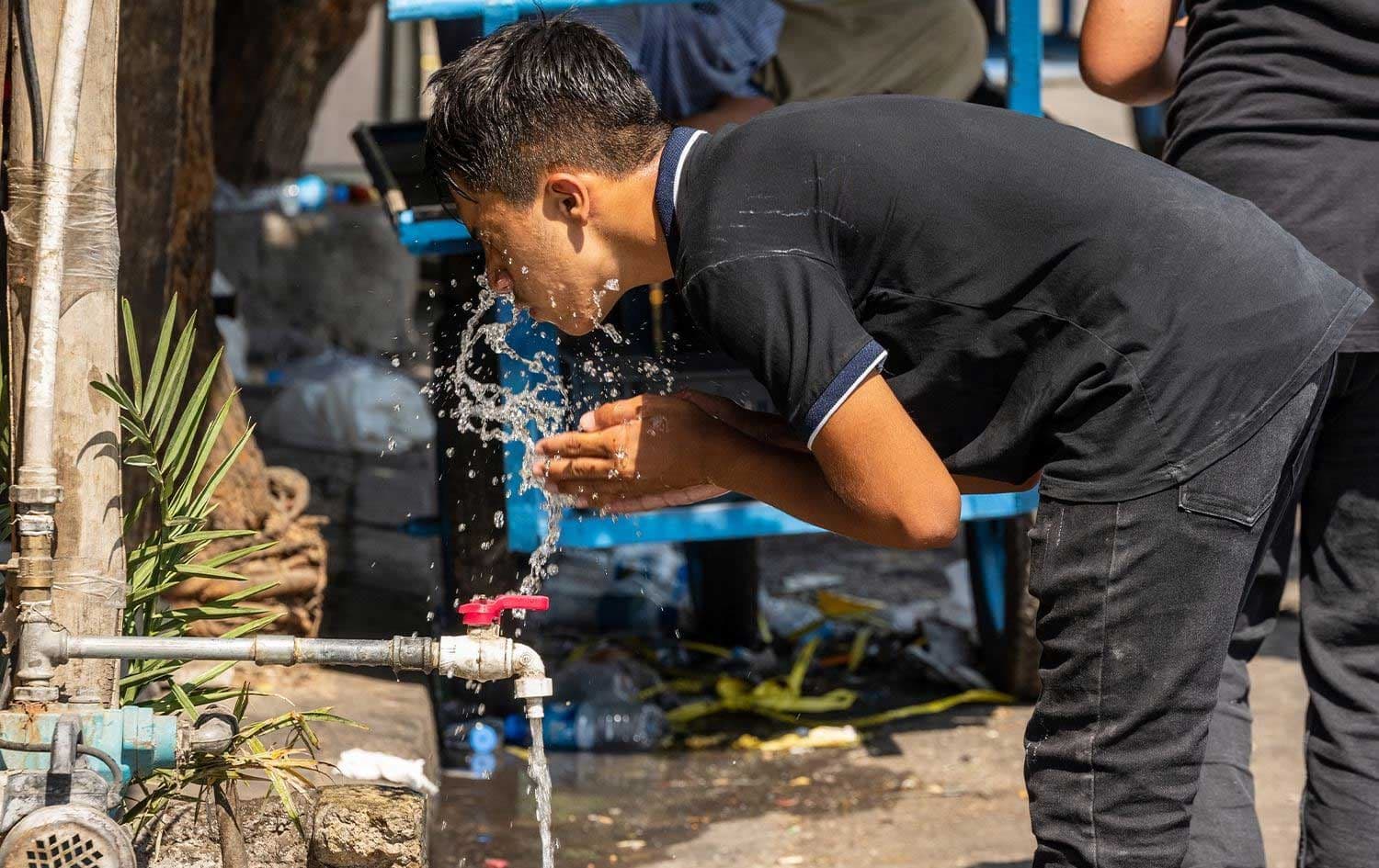 گەنجێک بەهۆی گەرماوە لە هەولێر دەمووچاوی فێنک دەکاتەوە؛ وێنە: بڵند تاهیر - رووداو