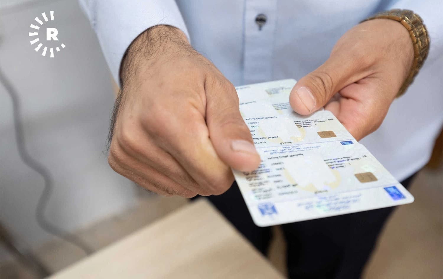 کەسێک کارتی بایۆمەتری بەدەستەوە گرتووە. وێنە: رووداو
