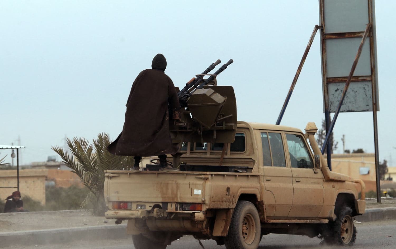 چەکدارێکی سوپای عەرەبیی سووریا بە دۆشکە تەقە دەکات. وێنە: AFP