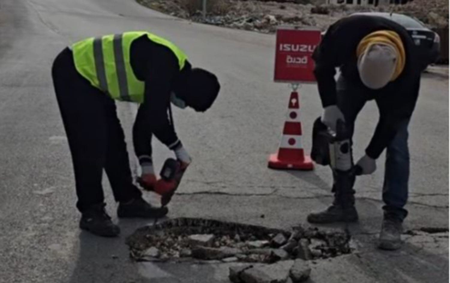 دوو کەس لە ئەندامانی گرووپەکە لەکاتی چاکردنی یەکێک لە شەقامەکانی سلێمانی