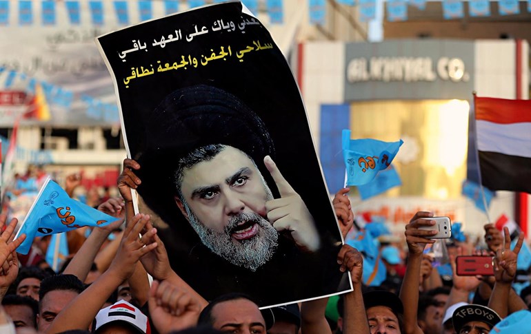 Followers of Shiite cleric Muqtada al-Sadr wave a poster with his image during a campaign rally in Baghdad on May 4, 2018. File photo: Karim Kadim/AP